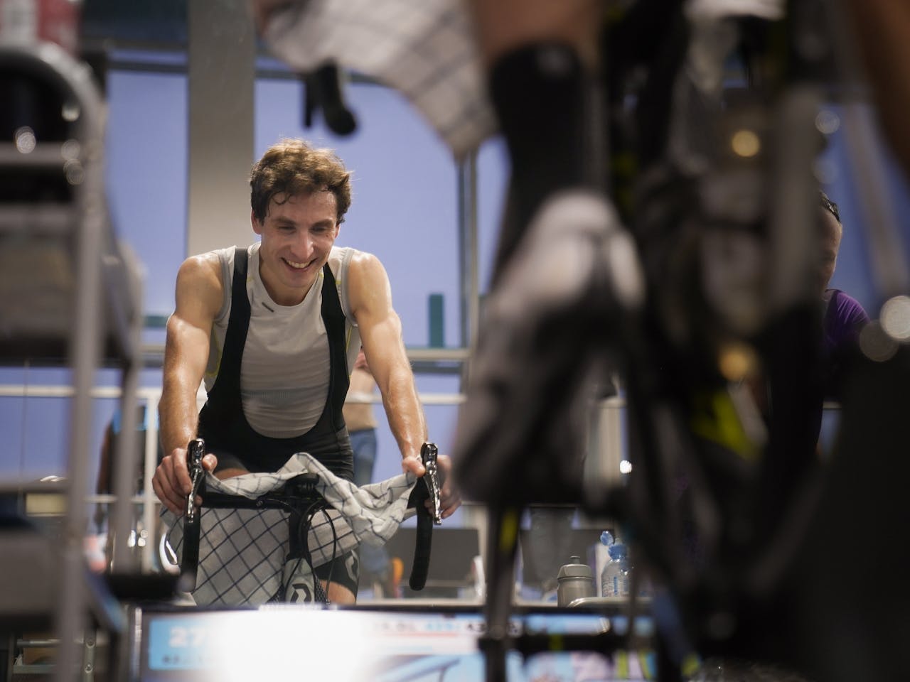 about-us-01 Man enjoying an intense indoor cycling workout, emphasizing fitness and healthy living.